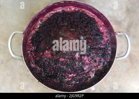 Faire bouillir la confiture de mûrier dans une casserole en métal sur feu ouvert Banque D'Images