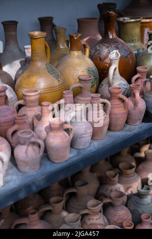 Beaucoup de cruches et vases en argile uniques et colorés faits à la main de formes diverses sur l'étagère dans le marché local Banque D'Images