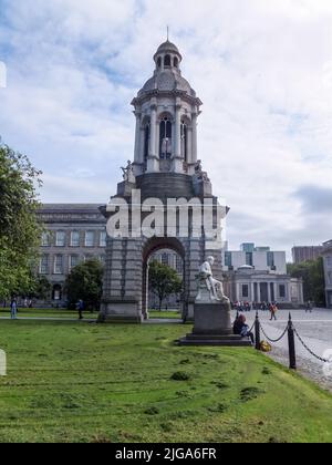 Les étudiants passent devant le Campanile 1853 de Trinity College, conçu par Sir Charles Lanyon et sculpté par Thomas Kirk, à Dublin, en Irlande. Banque D'Images