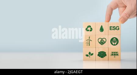 ESG concept de l'environnement, social et de gouvernance. Mots ESG sur bois bloc. Main tient des cubes en bois avec l'abréviation ESG debout avec d'autres ic ESG Banque D'Images