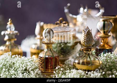 Une variété de parfums en verre décoratif et bouteilles de cristal sur une table avec le souffle de bébé. Configuration à l'entrée pour les invités à un mariage arabe. Banque D'Images