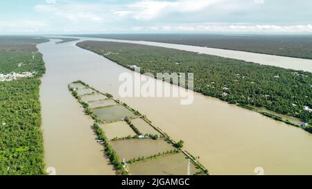 Grande antenne du mékong brun qui passe devant l'île près de Ben Tre au Vietnam Banque D'Images