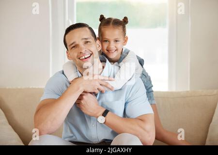 Les meilleures choses dans la vie sont les gens que vous aimez et les souvenirs que vous créez. Un homme liant avec son adorable fille à la maison. Banque D'Images