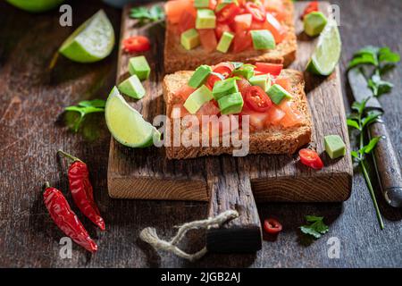 Toasts végétariens et chauds à base de tomates, d'avocat et de piment. Toasts croquants comme en-cas rapide. Banque D'Images