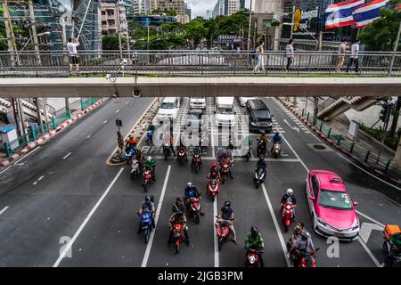 Bangkok, Thaïlande. 09th juillet 2022. Les gens marchent sur un pont piétonnier au-dessus de la circulation de voitures et de motos à une intersection animée dans le centre-ville de Bangkok. Crédit : SOPA Images Limited/Alamy Live News Banque D'Images