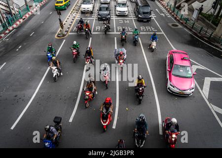 Bangkok, Thaïlande. 09th juillet 2022. Les motos transportant des passagers et les livraisons de nourriture dévalent dans une intersection très fréquentée pendant les heures de pointe dans le centre-ville de Bangkok. Crédit : SOPA Images Limited/Alamy Live News Banque D'Images