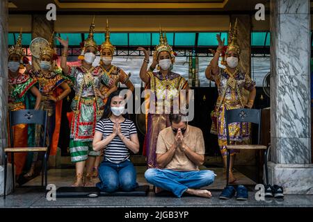 Bangkok, Thaïlande. 09th juillet 2022. Les gens prient tandis que les danseurs exécutent la danse thaïlandaise traditionnelle derrière eux au sanctuaire d'Erawan. (Photo par Matt Hunt/SOPA Images/Sipa USA) crédit: SIPA USA/Alay Live News Banque D'Images