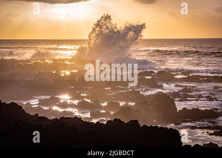 de hautes vagues dans l'océan s'écrasant sur des pierres pendant le coucher du soleil Banque D'Images