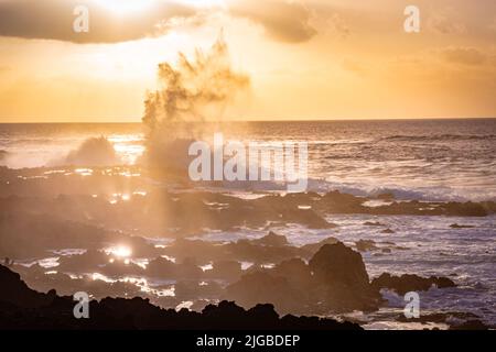 de hautes vagues dans l'océan s'écrasant sur des rochers pendant le coucher du soleil Banque D'Images