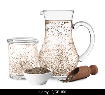 Carafe et pot d'eau avec graines de chia sur fond blanc Banque D'Images