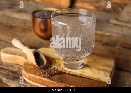 Verre avec eau et graines de chia sur fond de bois Banque D'Images