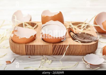 Support en bois avec coquilles d'œufs cassées sur la table, gros plan Banque D'Images