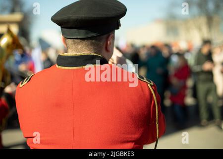 Orchestre avec instruments à vent. Trompettes en uniformes de cérémonie. Vêtements militaires rouges. Musiciens dans la rue. Banque D'Images