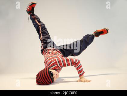garçon en position de breakdance, position de danse difficile, debout d'une main, debout sur la tête Banque D'Images