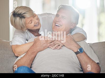 Être une famille signifie que vous faites partie de quelque chose de très merveilleux. Un couple mature assis sur le canapé à la maison. Banque D'Images