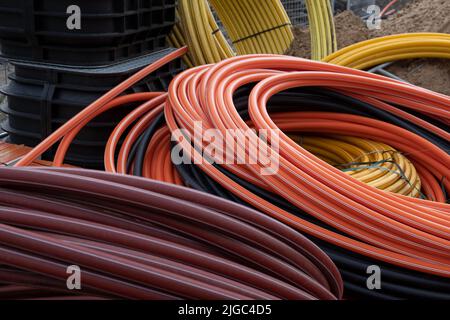 Installations de développement des communications, grande bobine de tubes PVC plastique. Les tuyaux sur le chantier protègent les câbles électriques Banque D'Images