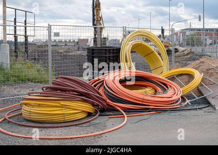 Installations de développement des communications, grande bobine de tubes PVC plastique. Les tuyaux sur le chantier protègent les câbles électriques Banque D'Images