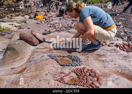 Dunbar, East Lothian, Écosse, Royaume-Uni, 9th juillet 2022. Championnat européen de pierre de superposition : les participants ont 3,5 heures pour créer une œuvre d'art des rochers de la plage Eye Cave. Photo : Marianne Winter des pays-Bas, qui a remporté ce concours en 2019 Banque D'Images