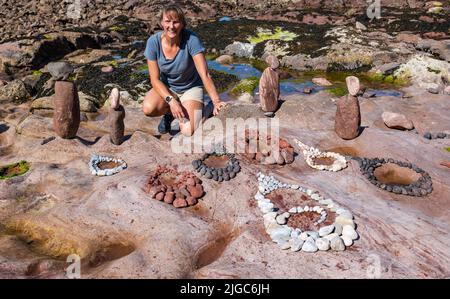 Dunbar, East Lothian, Écosse, Royaume-Uni, 9th juillet 2022. Championnat européen de pierre de superposition : les participants ont 3,5 heures pour créer une œuvre d'art des rochers de la plage Eye Cave. Photo : Marianne Winter des pays-Bas, qui a remporté ce concours en 2019 Banque D'Images