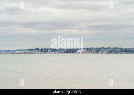 Vue vers Cowes sur l'île de Wight à travers le Solent vu de la plage de Calshot, Hampshire, Angleterre, Royaume-Uni Banque D'Images