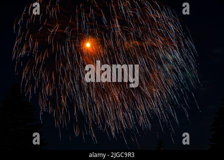 Montréal, Canada - 25 juin 2022: Feu de travail spectacle avec quart de lune en arrière-plan à la ronde à Montréal Banque D'Images