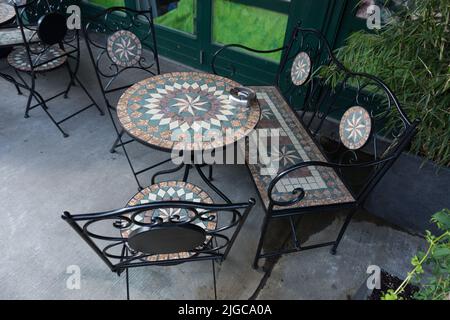 groupe de sièges en fonte noire richement décoré avec des incrustations avec table ronde chaises rétro et banc vintage devant un café-bar restaurant Banque D'Images