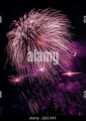 Montréal, Canada - 25 juin 2022: Feu de travail spectacle avec quart de lune en arrière-plan à la ronde à Montréal Banque D'Images