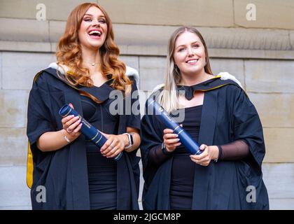 Les étudiantes glamour de la remise des diplômes de l'université de Dundee se posent pour faire prendre leurs photos à Dundee City Square, en Écosse Banque D'Images