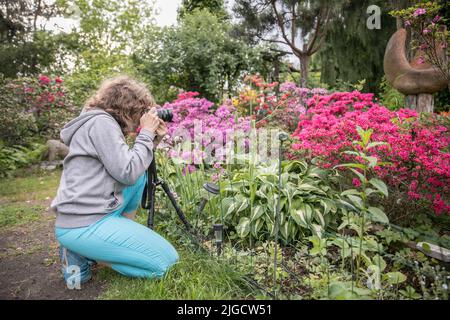 Le photographe prend des photos dans un magnifique jardin de printemps coloré en Pologne. Banque D'Images