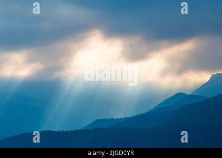 Des rayons du soleil qui brillent à travers les nuages de tempête dans les montagnes Rocheuses du Colorado. Banque D'Images