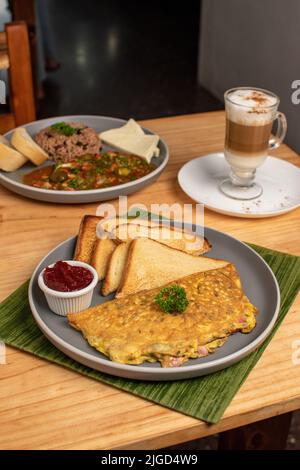 Omelette et toasts incroyables avec un capuccino et petit déjeuner en arrière-plan Banque D'Images