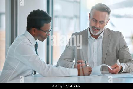 Nous avons tous besoin d'un mentor. Deux hommes d'affaires signent un contrat dans un bureau. Banque D'Images