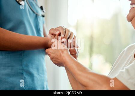 Aucun miracle ne se voit. Une infirmière tenant la main d'un homme plus âgé. Banque D'Images