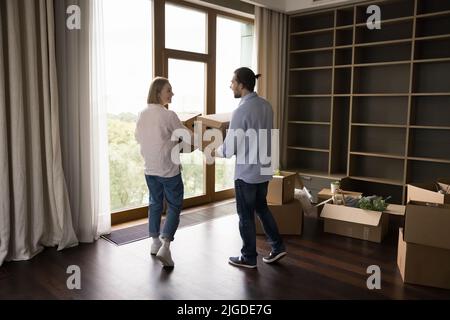 Un couple heureux de locataires, propriétaires de maisons déménatant dans un appartement moderne Banque D'Images