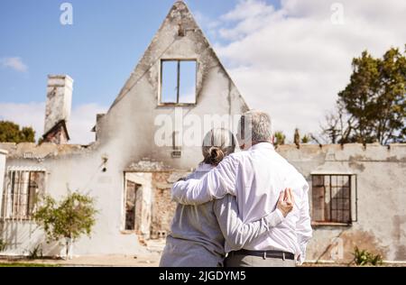 Où allons-nous maintenant. Un couple senior se réconfortant après avoir perdu leur maison à un incendie. Banque D'Images