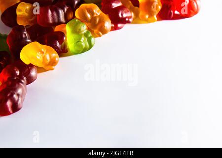 Des animaux délicieux de différentes couleurs avec du jus de fruit se trouvent dans le coin supérieur gauche du cadre sur un fond blanc Banque D'Images