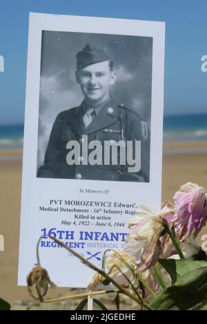 Des fleurs et une photo sur une pierre commémorative commémorent Edward Morozewicz, médique, tué à Omaha Beach le 6 juin 1944, à l'âge de 22 ans, Arromanches-les-bains, FRA Banque D'Images