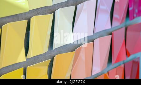 De nombreuses plaques carrées en métal de couleur différente suspendues. Pièces en acier courbé colorées. Ressemble à des notes adhésives. Banque D'Images