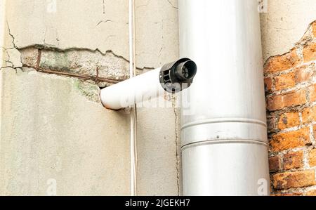 Morceau de tube en plastique dépassant de mur de brique de ciment Banque D'Images