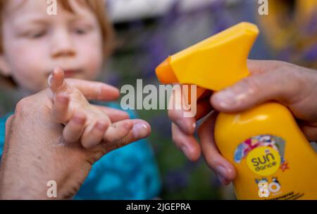 Berlin, Allemagne. 04th juillet 2022. Un homme met de la crème solaire sur la main de son enfant. Credit: Monika Skolimowska/dpa/Alay Live News Banque D'Images