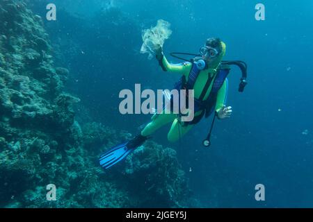 Un plongeur collectant du plastique qui cause la pollution de la mer Banque D'Images
