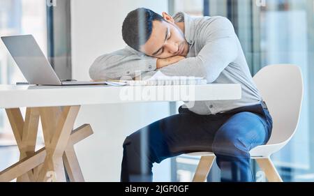 Le patron ne le saura jamais : un jeune homme d'affaires épuisé a fait une sieste à son bureau. Banque D'Images