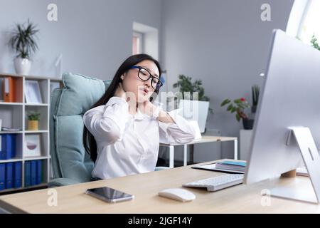 Jeune femme asiatique belle employée de bureau, indépendant, femme d'affaires en lunettes et chemise blanche, assis à la table à l'ordinateur, fatigué, échappement Banque D'Images