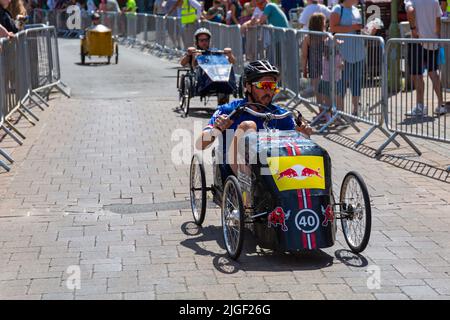 Ringwood, Hampshire, Royaume-Uni. 10th juillet 2022. Le Grand Prix de la voiture à pédales britannique a eu lieu pour la première fois dans la ville de Ringwood en 1987. L'événement attire désormais des milliers de spectateurs chaque année pour observer les « voitures » lorsqu'elles tournent autour de la piste en ville. Les foules affluent pour voir l'excitation par une chaude journée ensoleillée. Crédit : Carolyn Jenkins/Alay Live News Banque D'Images