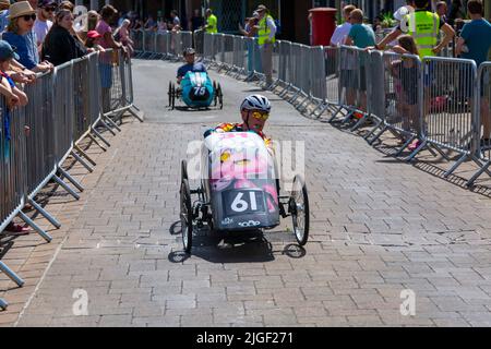 Ringwood, Hampshire, Royaume-Uni. 10th juillet 2022. Le Grand Prix de la voiture à pédales britannique a eu lieu pour la première fois dans la ville de Ringwood en 1987. L'événement attire désormais des milliers de spectateurs chaque année pour observer les « voitures » lorsqu'elles tournent autour de la piste en ville. Les foules affluent pour voir l'excitation par une chaude journée ensoleillée. Crédit : Carolyn Jenkins/Alay Live News Banque D'Images