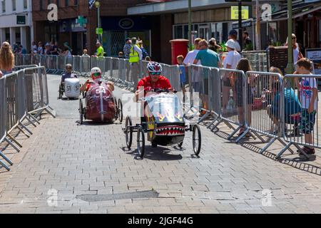 Ringwood, Hampshire, Royaume-Uni. 10th juillet 2022. Le Grand Prix de la voiture à pédales britannique a eu lieu pour la première fois dans la ville de Ringwood en 1987. L'événement attire désormais des milliers de spectateurs chaque année pour observer les « voitures » lorsqu'elles tournent autour de la piste en ville. Les foules affluent pour voir l'excitation par une chaude journée ensoleillée. Crédit : Carolyn Jenkins/Alay Live News Banque D'Images