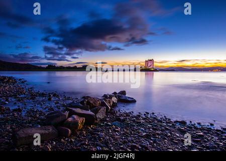 Une belle vue au crépuscule du château de Stalker dans les Highlands d'Écosse au Royaume-Uni. La tour se trouve sur un îlot de marée sur le Loch Laich, une entrée au large du Loch Li Banque D'Images