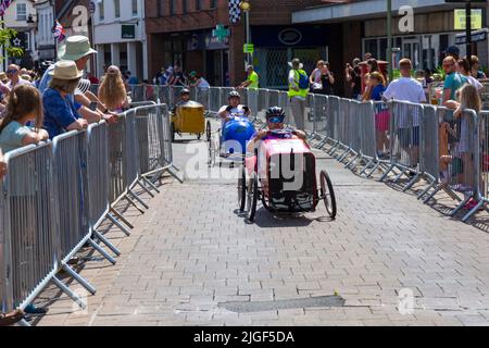 Ringwood, Hampshire, Royaume-Uni. 10th juillet 2022. Le Grand Prix de la voiture à pédales britannique a eu lieu pour la première fois dans la ville de Ringwood en 1987. L'événement attire désormais des milliers de spectateurs chaque année pour observer les « voitures » lorsqu'elles tournent autour de la piste en ville. Les foules affluent pour voir l'excitation par une chaude journée ensoleillée. Crédit : Carolyn Jenkins/Alay Live News Banque D'Images