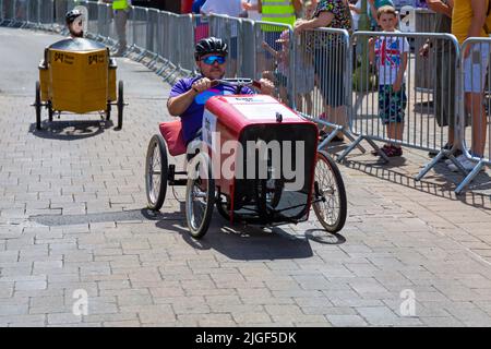 Ringwood, Hampshire, Royaume-Uni. 10th juillet 2022. Le Grand Prix de la voiture à pédales britannique a eu lieu pour la première fois dans la ville de Ringwood en 1987. L'événement attire désormais des milliers de spectateurs chaque année pour observer les « voitures » lorsqu'elles tournent autour de la piste en ville. Les foules affluent pour voir l'excitation par une chaude journée ensoleillée. Crédit : Carolyn Jenkins/Alay Live News Banque D'Images
