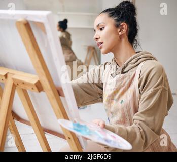 De son esprit à la toile. Photo en grand angle d'une jeune femme attrayante peint sur une toile dans son studio. Banque D'Images